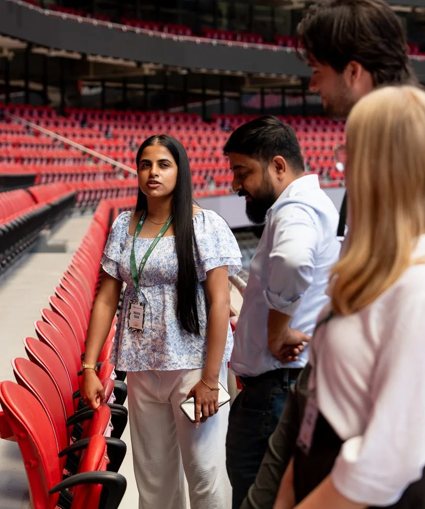 Participants talking in the stands during a stadium visit in Lisbon